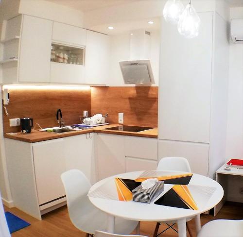 eine kleine Küche mit einem Tisch und einem Waschbecken in der Unterkunft Luksusowy Apartament Nad Zalewem in Serock