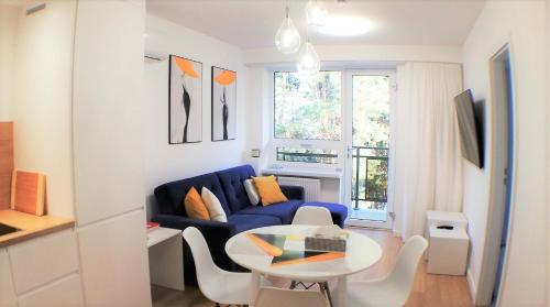 sala de estar con sofá azul y mesa en Luksusowy Apartament Nad Zalewem, en Serock