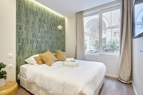 une chambre avec un grand lit blanc avec une fenêtre dans l'établissement Residence Le Marais Beaubourg by Studio prestige, à Paris