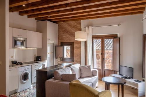 a living room with a couch and a kitchen at Apartamentos Santa Fe in Toledo