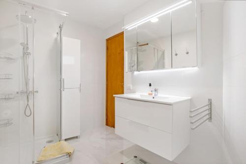 a white bathroom with a sink and a shower at Los Geranios 407 in Adeje
