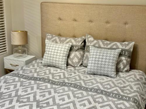 a bedroom with a bed with pillows and a headboard at LuxApart Kalisz Loft in Kalisz