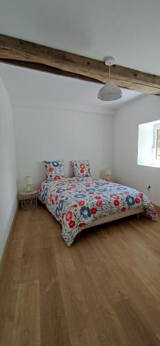 1 dormitorio con cama con edredón en Le gîte de l'Ecurie en Forges-la-Forêt