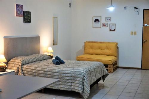 una habitación de hotel con 2 camas y una silla en Alem PA4 Mendoza en Mendoza