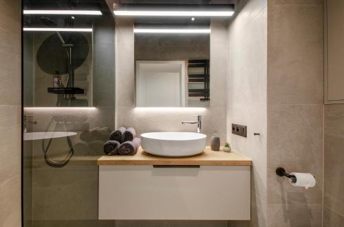 a bathroom with a white sink and a mirror at Apartament Manufaktura Centrum z klimatyzacją in Łódź