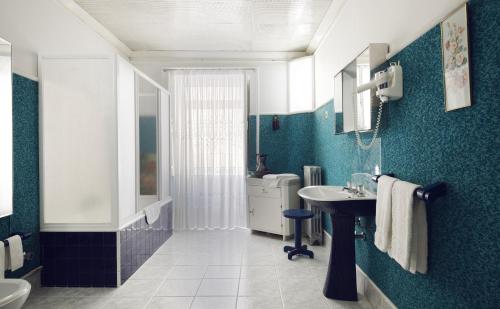 a blue bathroom with a sink and a toilet at Casa do Comendador in Manteigas