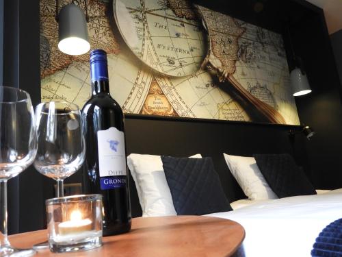 Bladel的住宿－hotel de Tipmast，一张桌子上坐着一瓶葡萄酒和一杯