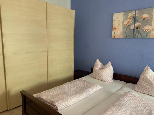 a bedroom with two beds and a painting on the wall at Ferienwohnung am Markt 2 in Annaberg-Buchholz