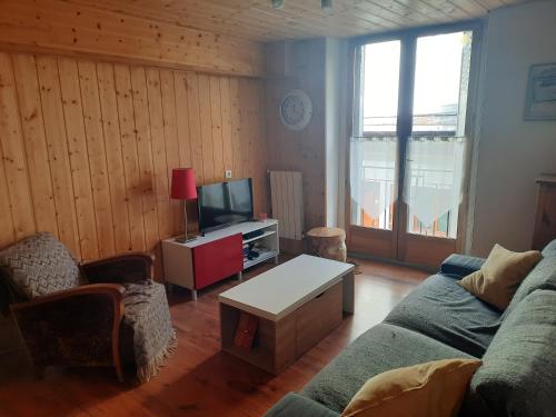 Una sala de estar con un sofá y un televisor. en Le Cocon, en Luchon
