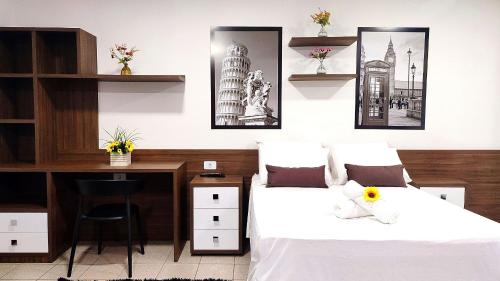 a bedroom with two beds and a desk at Lindos Studios Centro/Wifi/Garagem in Foz do Iguaçu