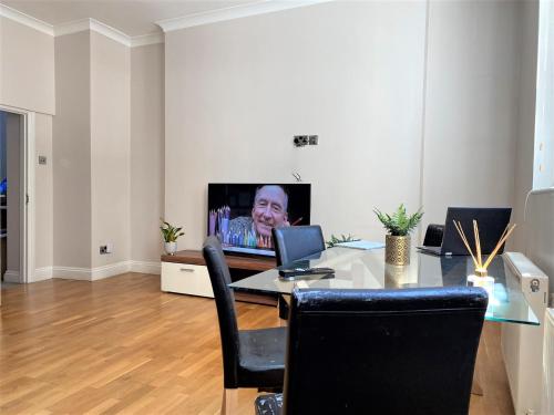 a dining room with a table and a television at Sight Flats - SF01 - One Bedroom in London