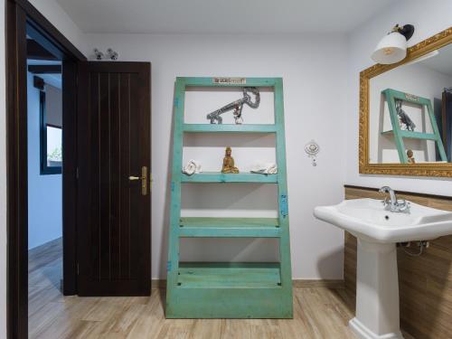 a bathroom with a green shelf next to a sink at Viviendas vacacionales San Mateo in Vega de San Mateo