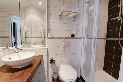 a bathroom with a sink and a toilet and a shower at Source Hôtel in Paris