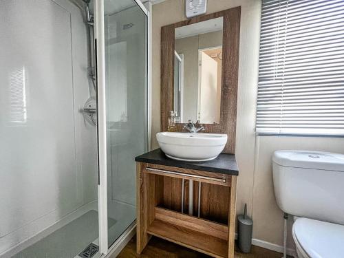 a bathroom with a sink and a shower and a toilet at Lovely 6 Berth Caravan At Seaview Holiday Park In Kent Ref 47001d in Whitstable