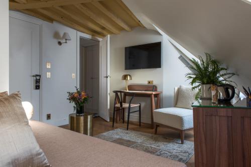 1 dormitorio con 1 cama, 1 mesa y 1 silla en Hôtel Fougère, en París