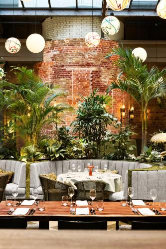 a restaurant with tables and chairs and a brick wall at Telegraphenamt in Berlin