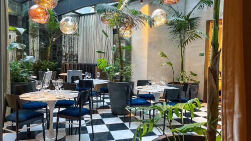 a restaurant with tables and chairs and potted plants at Hotel Magnolia Santiago in Santiago