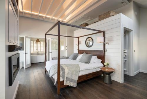 a bedroom with a canopy bed and a bathroom at The Other 43 in Kinsale