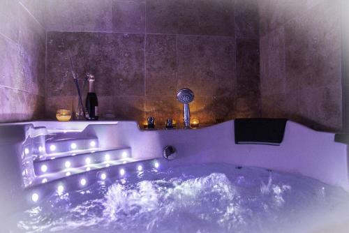 Baño púrpura con bañera con luces. en Chez Aurélia - Chambres & Table d'hôtes, en La Couture-Boussey