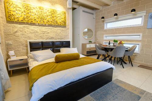 a bedroom with a bed and a table with chairs at אחוזת מיא - סוויטות בוטיק על המים in Goren