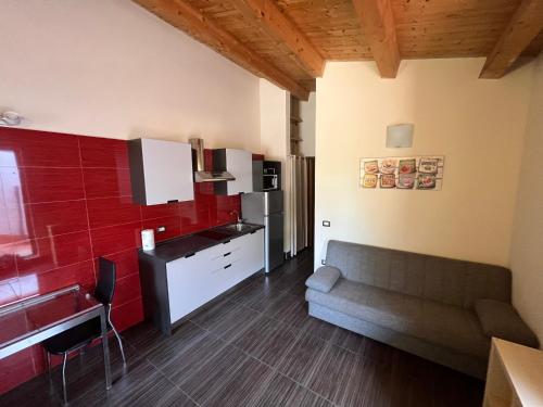 a living room with a couch and a kitchen at Green Orange Catania Ognina in Catania
