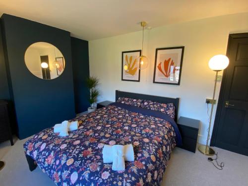 靈伍德的住宿－Tipsy Cottage & Games Cabin with fire-pit and BBQ，一间卧室配有一张带蓝色墙壁和镜子的床