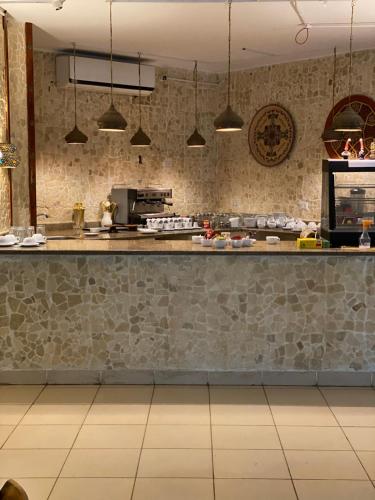 a kitchen with a counter and a stone wall at Blue Vision Diving Hotel in Marsa Alam City
