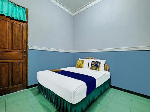 a bedroom with a bed in a blue room at SPOT ON 91912 Hotel Citra Dewi 2 in Semarang