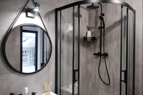 a bathroom with a shower and a mirror at Loft Parkowa in Przemyśl