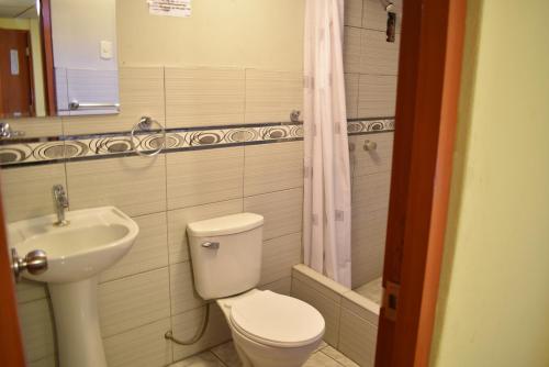 een badkamer met een toilet en een wastafel bij Hotel Acuario in Churín