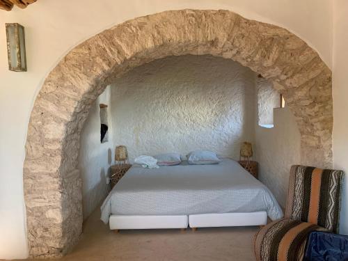 ein Schlafzimmer mit einem Bett in einem steinernen Torbogen in der Unterkunft Comme un hameau de charme dominant l'Océan in Essaouira