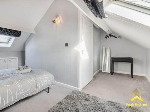 バクストンにある30a Peak Mews - Spacious 3 bedroom apartment at the heart of Buxtonの白いベッドルーム(ベッド1台、テーブル付)