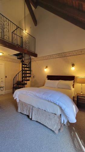 a bedroom with a large bed and a staircase at The Elizabeth Inn and Restaurant in Bethel