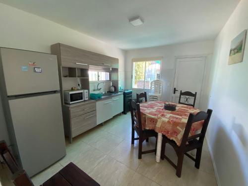 a kitchen with a dining table and a refrigerator at Philadelphia3 dormitorios in Punta del Este