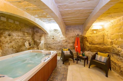 a large bathroom with a tub in a stone building at Ta Kristoff Holiday Home in Qala
