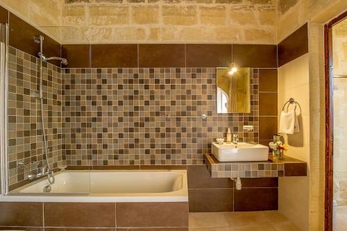 a bathroom with a tub and a sink at Ta' Majsi Holiday Home in Xlendi