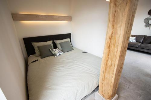 een slaapkamer met een bed met een houten paal bij Natural Green Loft in Bergen