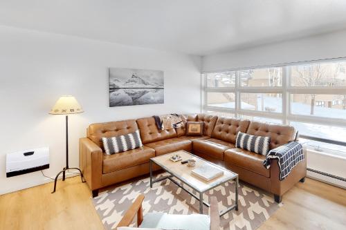 a living room with a brown couch and a table at Revitalize in Vail in Vail