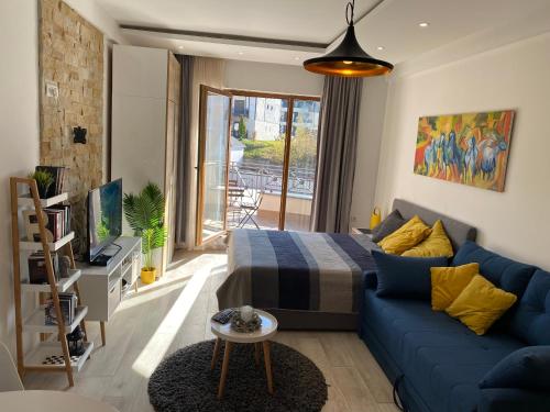 un soggiorno con divano blu e letto di Milmari Resort - Apartman L43 a Kopaonik