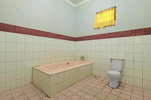 a bathroom with a bath tub and a toilet at Collection O 91914 Hotel Citra Dewi 2 Int's in Semarang
