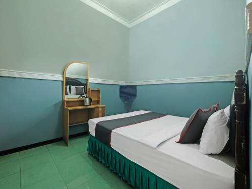 a bedroom with a bed and a table with a mirror at Collection O 91914 Hotel Citra Dewi 2 Int's in Semarang