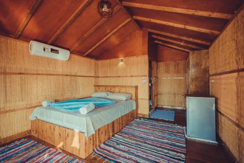a bedroom with a bed in a wooden room at Crazy Horse Camp in Nuweiba