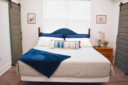 a bedroom with a large bed with a blue headboard at The Aymara Boutique Spacious New Construction DWTN in Pensacola
