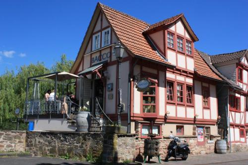 un edificio con personas sentadas en un balcón en BACCO Bed & Breakfast, en Rotenburg an der Fulda