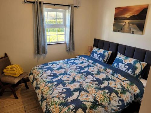a bedroom with a bed with a colorful comforter and a window at Murray's Lodge: Self-Catering Accommodation. in Cavan