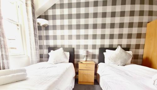 two beds sitting next to each other in a bedroom at Aberfoyle Inn in Aberfoyle