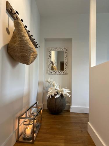 a hallway with a basket and a vase with candles at Luxe et Charme - Le Carré Saint-Silain - Meublé de tourisme 3 étoiles in Périgueux
