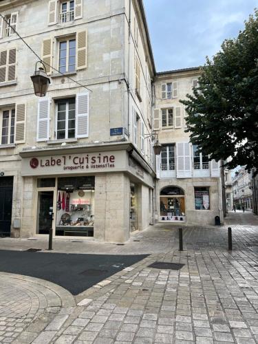 een lege straat met een gebouw met een winkel bij Luxe et Charme - Le Carré Saint-Silain in Périgueux