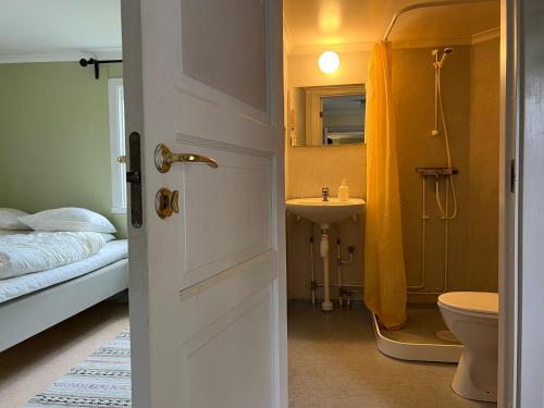 uma casa de banho com uma cama, um lavatório e um WC. em Lilla Backstugan em Nora
