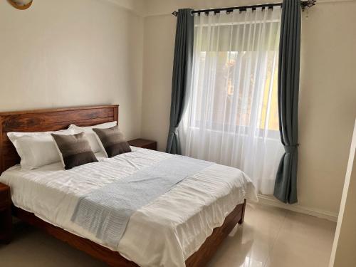 um quarto com uma cama grande e uma janela em Spacious 3 Bedroom Apartment Excellent Location Bugolobi Kampala - Immersion 1 em Kampala